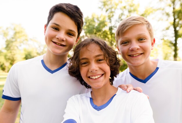 Crianças em trajes esportivos de futebol sorrindo