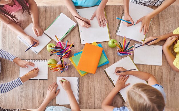 Crianças em volta da mesa da escola