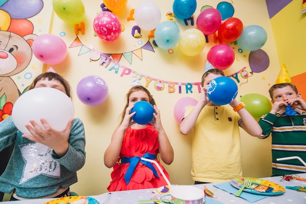 Crianças explodindo balões na festa de aniversário