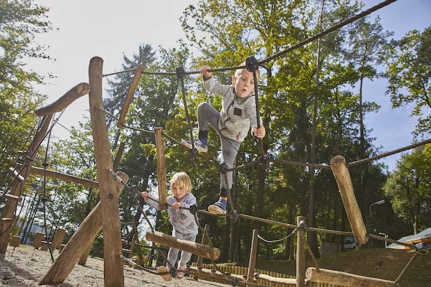 Crianças felizes brincando no parquinho de madeira durante o dia