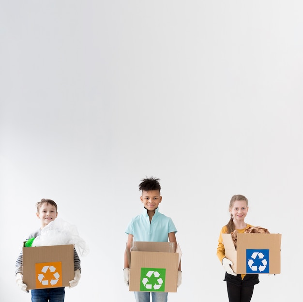 Crianças felizes, segurando caixas de reciclagem