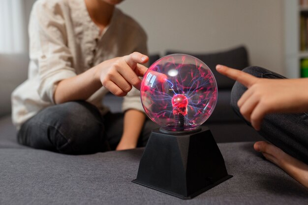Crianças interagindo com uma bola de plasma