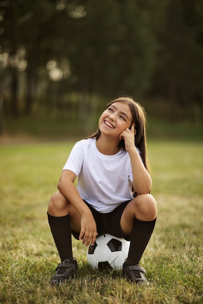 Crianças jogando futebol supervisionadas por treinador de futebol