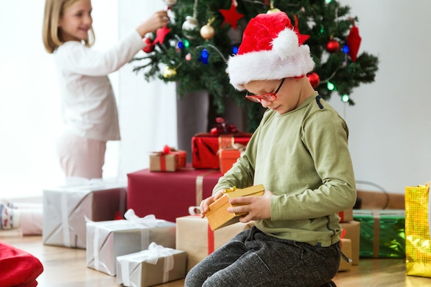 Crianças na manhã de Natal com presentes e árvore