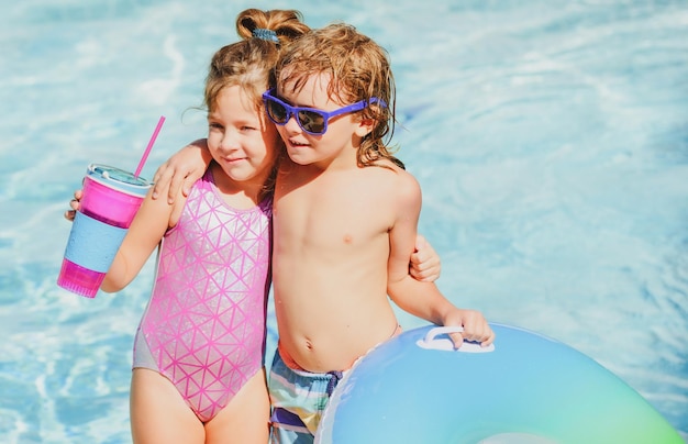 Crianças na piscina de verão nas férias de verão crianças na piscina amizade nas férias de verão