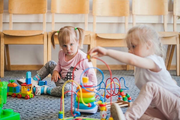 Crianças no jardim de infância com brinquedos