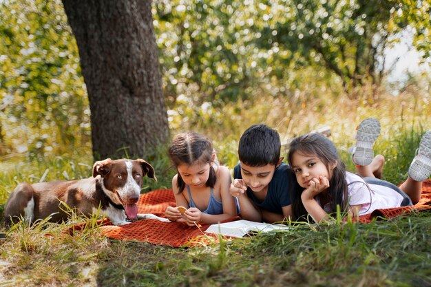 Crianças passando tempo juntos ao ar livre no cobertor curtindo a infância