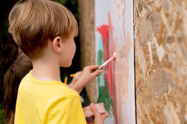 Foto grátis crianças pintando com pincéis de perto