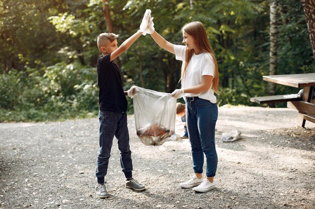 Crianças recolhe lixo em sacos de lixo no parque