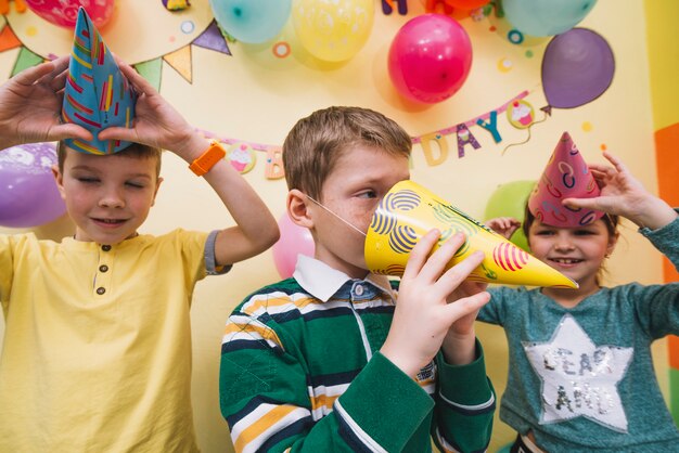 Crianças se divertindo com chapéus de festa