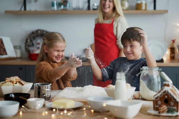 Crianças se divertindo enquanto preparam bolos para biscoitos de Natal