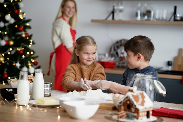 Crianças se divertindo muito enquanto assam biscoitos para o Natal