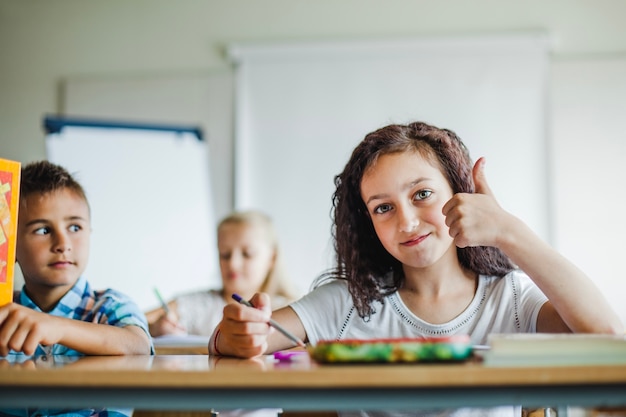 Crianças sentadas na mesa da escola