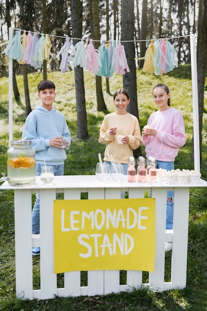 Crianças sorridentes de tiro completo com limonada