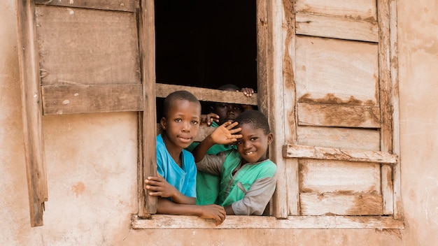 Crianças sorridentes de tiro médio na janela