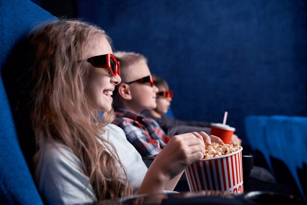 Crianças usando óculos 3d assistindo filme engraçado no cinema