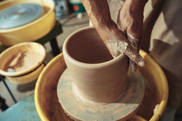 Criando um pote ou vaso de argila branca close-up. Mestre pote.