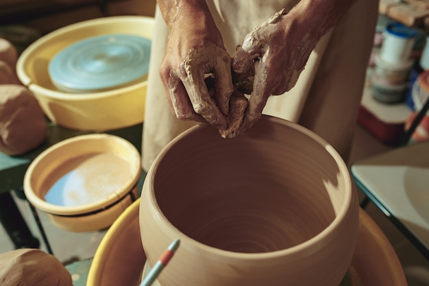 Criando um pote ou vaso de argila branca close-up. Mestre pote.