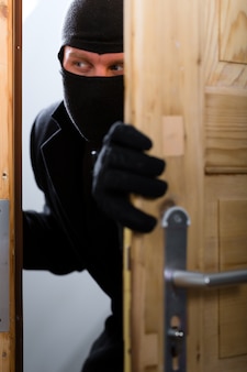 Crime de roubo - ladrão abrindo uma porta