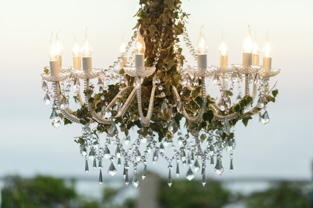 Cristais pendurados no candelabro decorado com vegetação