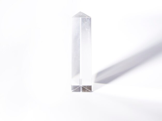 Cristal geométrico com sombra escura, isolada no fundo branco