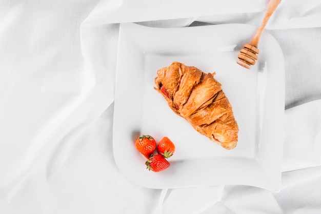 Foto grátis croissant e morangos no prato