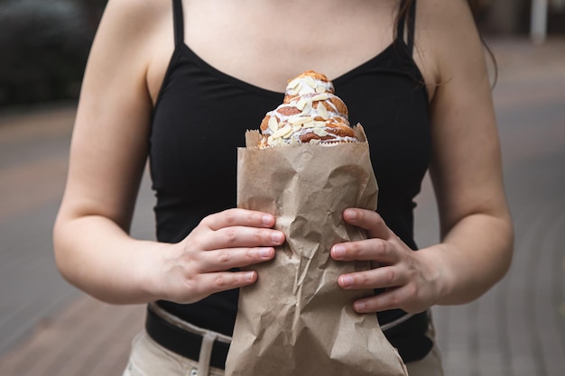 Foto grátis croissant em um saco de papel artesanal nas mãos femininas