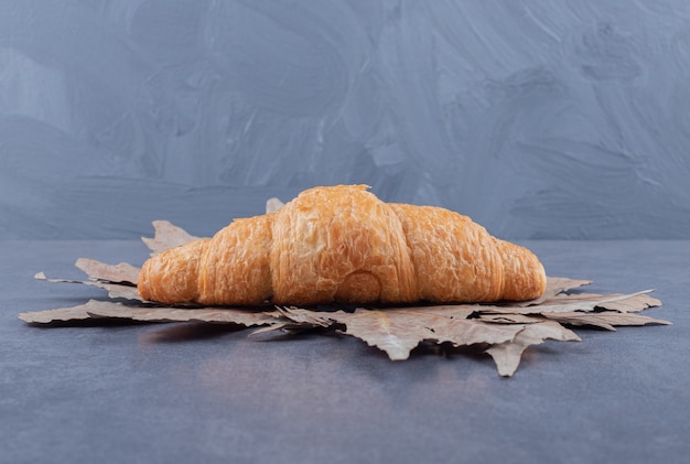 Croissant francês recém-assado em fundo cinza.