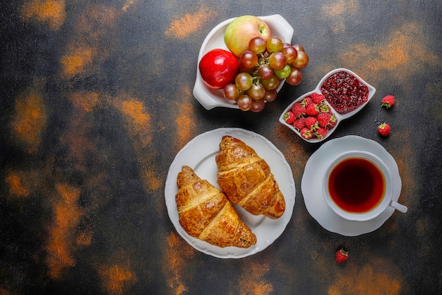 Croissants acabados de fazer com compota de framboesa e frutos de framboesa.