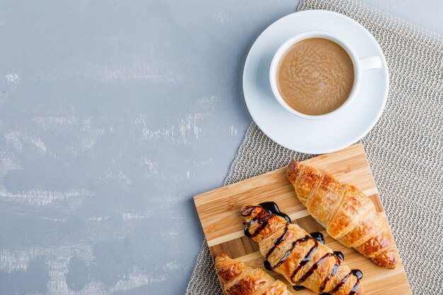 Croissants com café, tábua, plana.