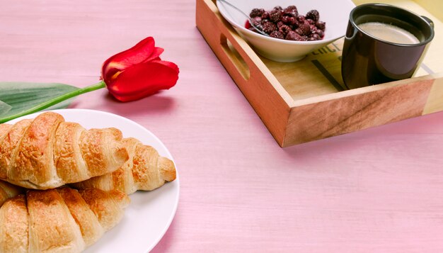 Croissants com tulipa vermelha e bandeja com bagas