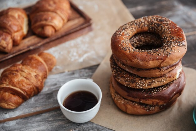 Croissants de pastelaria na mesa perto da xícara de café.