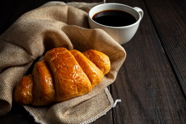 croissants e café na mesa de madeira velha.