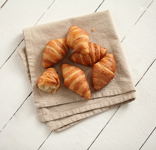 Croissants franceses frescos numa toalha de mesa