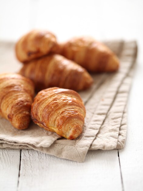 Croissants franceses frescos numa toalha de mesa