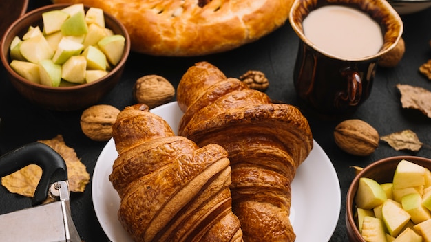 Foto grátis croissants perto de maçãs e leite