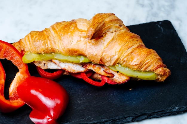 Croissants recheados com fatias de frango frito e legumes