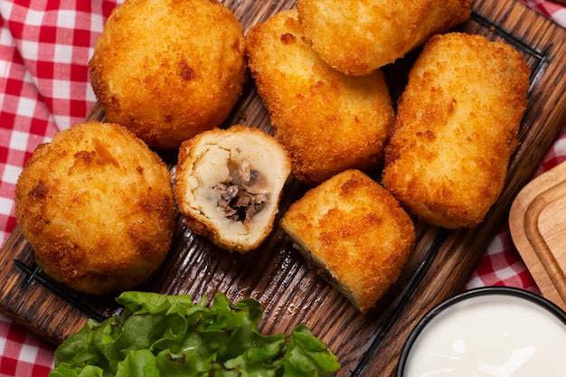 Croquetes de comida plana lay na placa de madeira