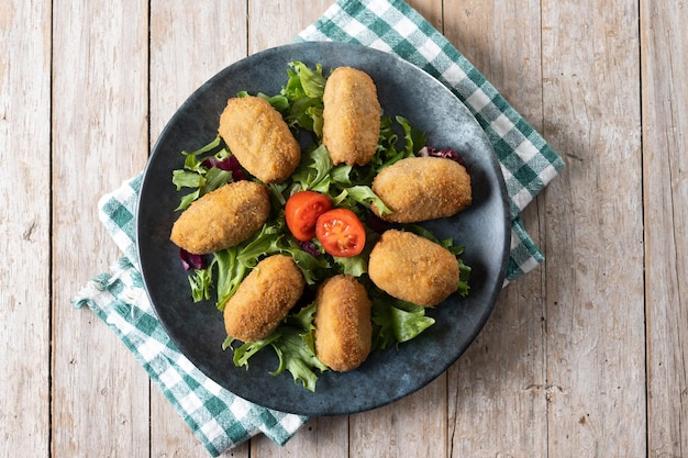 Croquetes fritos espanhóis tradicionais na mesa de madeira