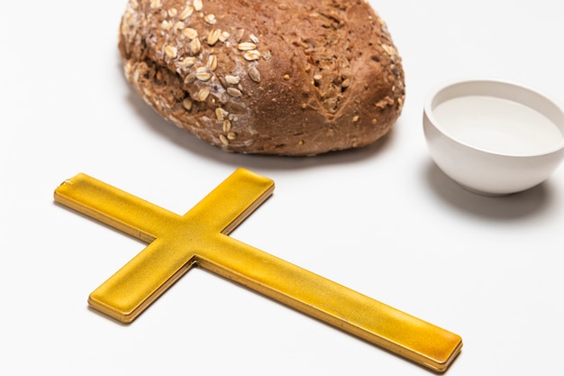 Foto grátis cruz de close-up com pão e água