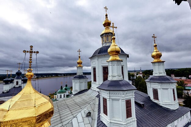 Cruzes ortodoxas orientais em cúpulas de ouro, cúpulas, contra o céu azul com nuvens. Igreja Ortodoxa