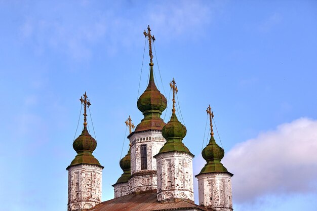 Cruzes ortodoxas orientais em cúpulas de ouro, cúpulas, contra o céu azul com nuvens. Igreja Ortodoxa
