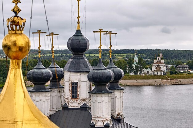 Cruzes ortodoxas orientais em cúpulas de ouro, cúpulas, contra o céu azul com nuvens. Igreja Ortodoxa