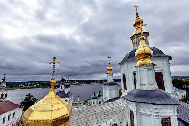 Cruzes ortodoxas orientais em cúpulas de ouro, cúpulas, contra o céu azul com nuvens. Igreja Ortodoxa