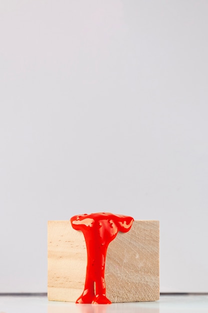 Cubo de madeira com pingos de tinta laranja