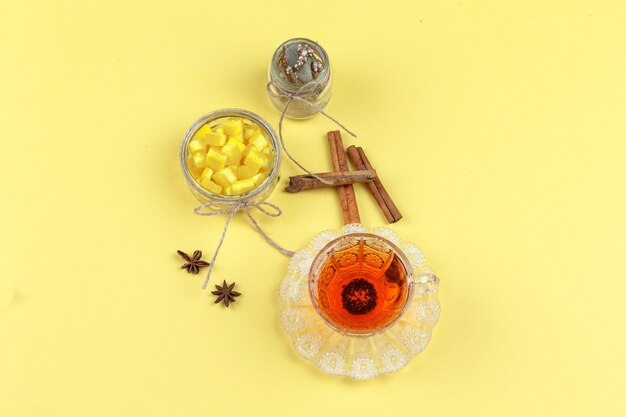 Cubos de açúcar, especiarias, ervas secas e chá em uma xícara de vidro