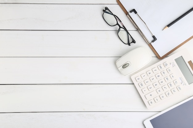 Óculos, calculadora e tablet na mesa branca e limpa