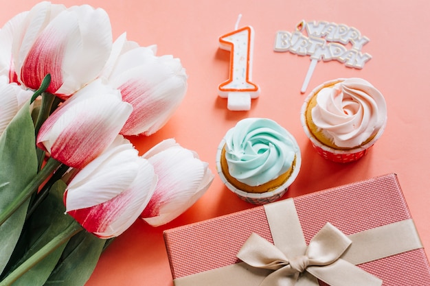 Foto grátis cupcake de aniversário com presentes e flores