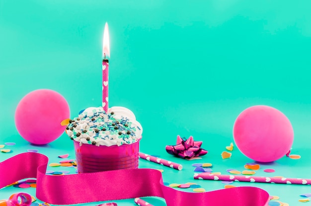 Foto grátis cupcake de aniversário com vela e balões