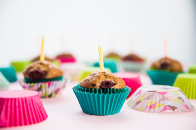 Foto grátis cupcake de aniversário nos suportes de papel com velas